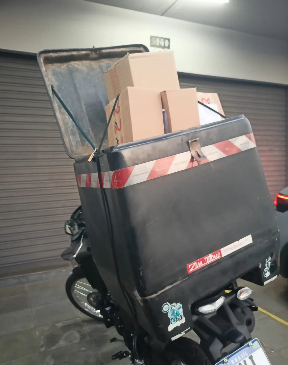 Moto com baú carregado para entrega